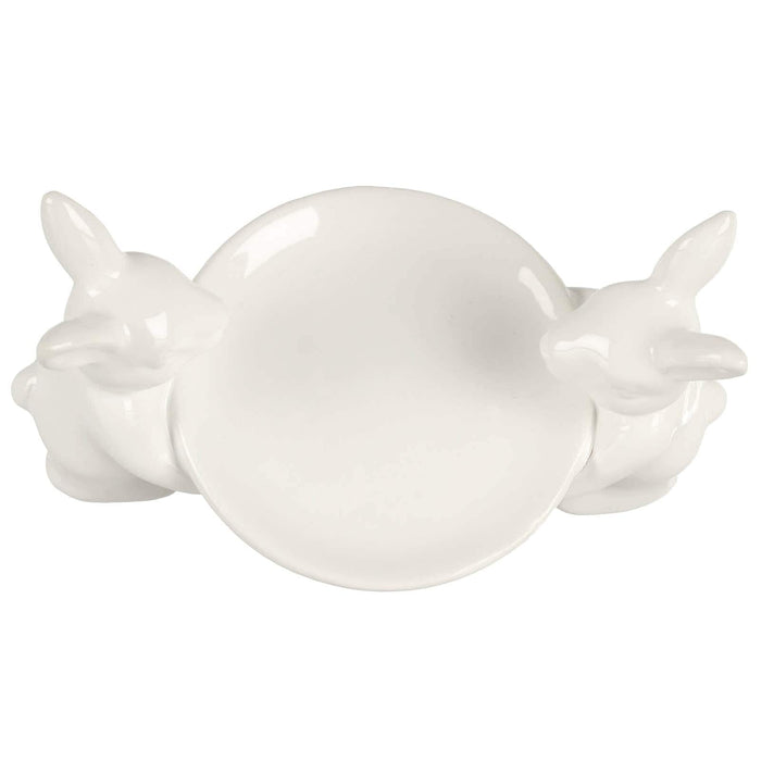 Overhead view of a white cake plate with 2 white rabbits