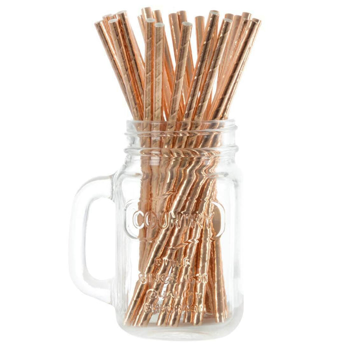 Rose gold drinking straws in a glass mason jar on a white background