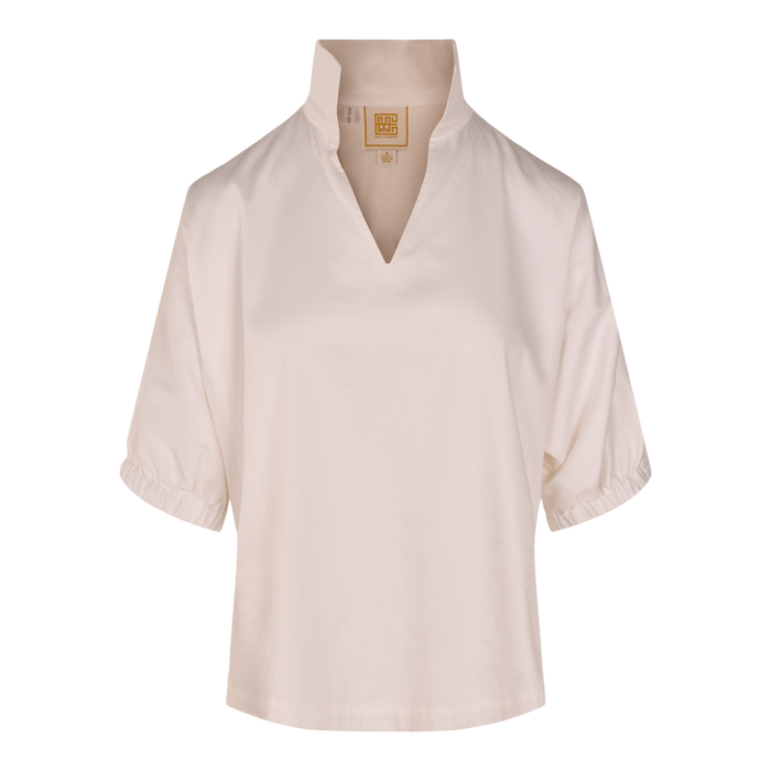 The Poppy Top is a cream-colored, loose-fitting blouse with a stand-up collar, V-shaped neckline, elasticized cuffs, and relaxed fit. Made from smooth, lightweight cotton poplin for effortless comfort.