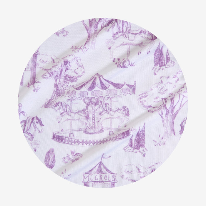 Round fabric swatch with purple carousel design on a white background