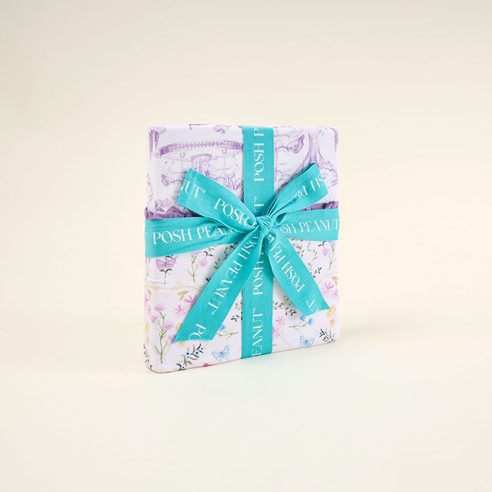 Blanket wrapped with floral pattern and turquoise ribbon on a light beige background