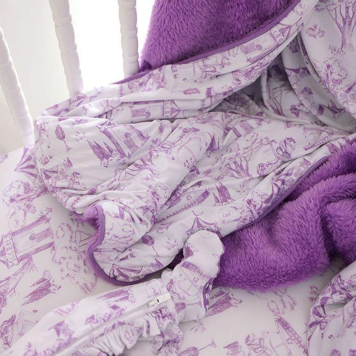 Purple and white patterned blanket draped over a chair with a fluffy purple pillow.