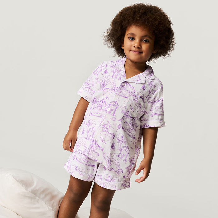 Child wearing a purple and white patterned outfit on a plain background