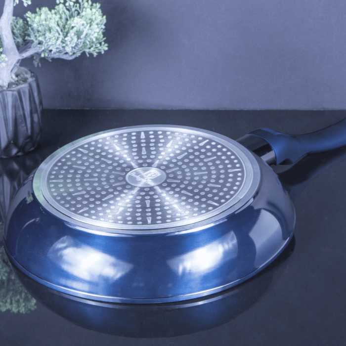Blue frying pan with a perforated base on a dark surface