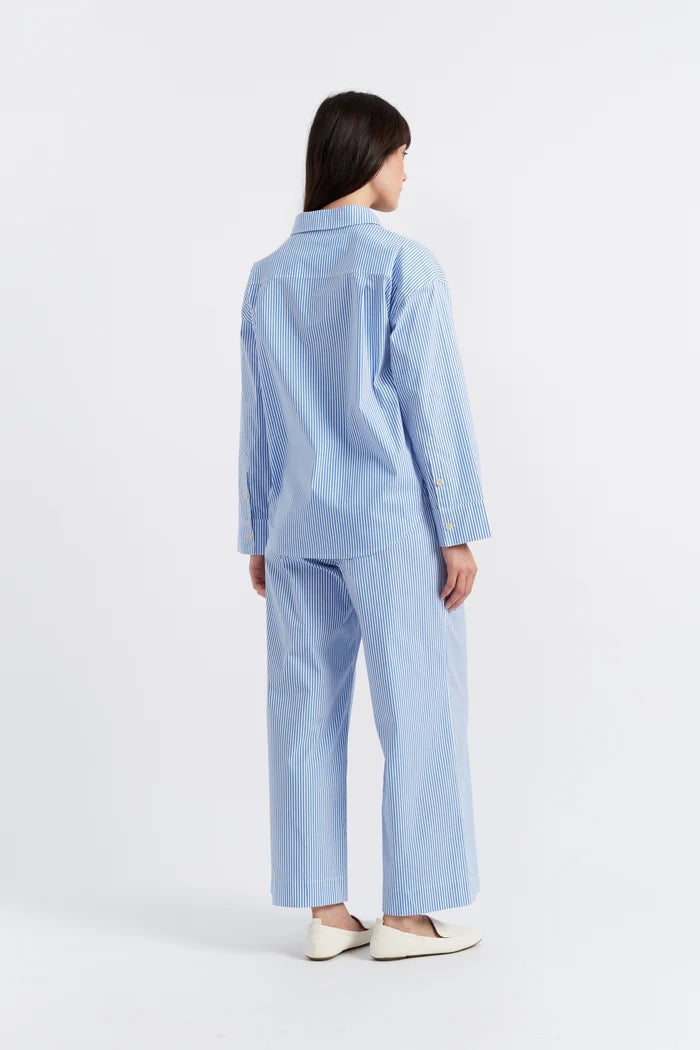 Person wearing a light blue outfit on a white background