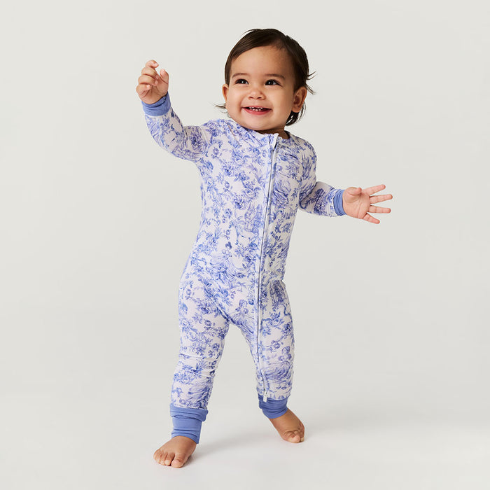 Child wearing a blue floral one piece on a light gray background