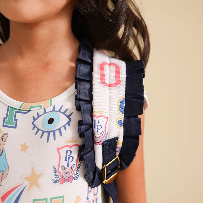 Close-up of a person wearing a colorful shirt with a graphic design, wearing  a bag with a visible brand logo.