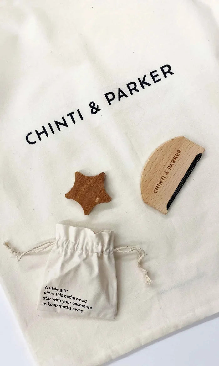 Chinti & Parker wooden star and circle toys on a branded drawstring bag.
