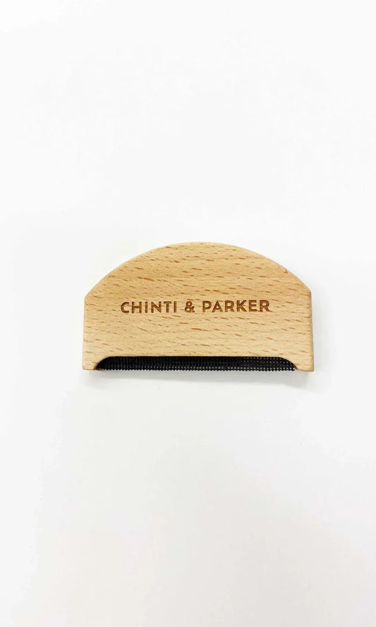 Wooden comb with 'Chinti & Parker' branding on a white background