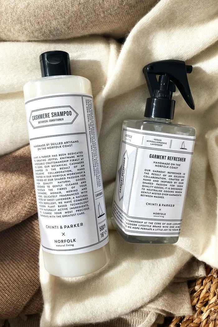 Two bottles of Thymes & Parker products on a textured fabric background