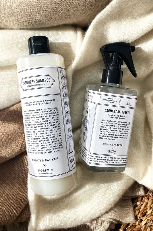 Two bottles of Thymes & Parker products on a textured fabric background