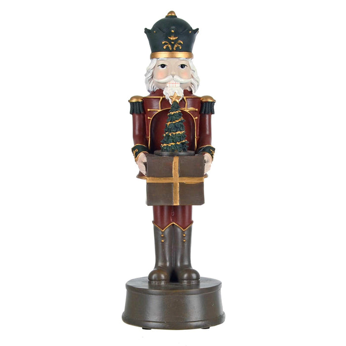 Christmas nutcracker figure holding a gift and Christmas tree