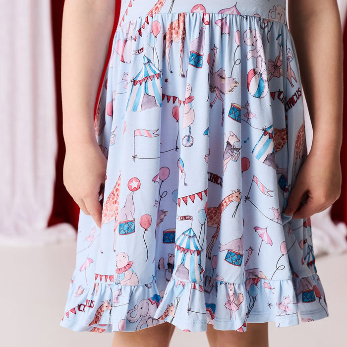 Children's dress with a colorful circus-themed print on a plain background