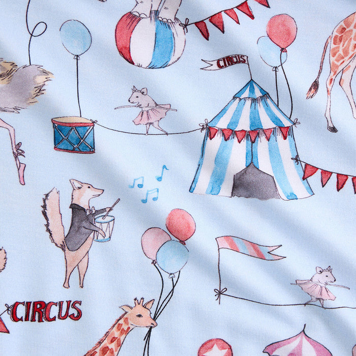 Circus-themed fabric with animals, balloons, and a tent on a light blue background.