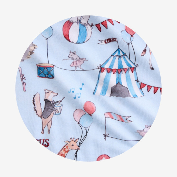 Fabric with circus-themed design featuring animals and circus elements on a light blue background.