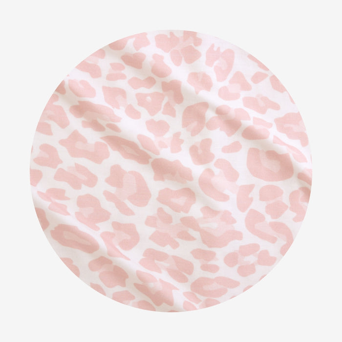 Round pink and white patterned object on a light gray background