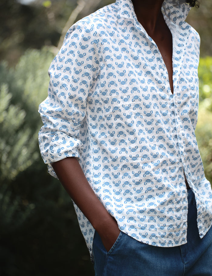 Person wearing a white shirt with blue patterns outdoors