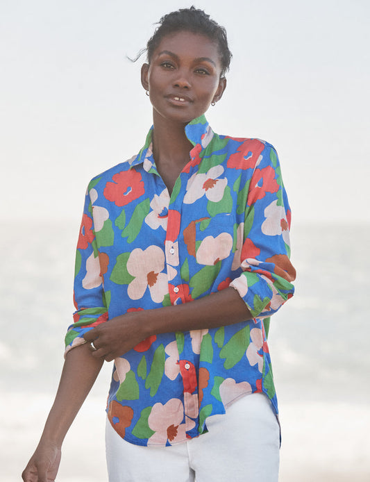 Woman wearing a colorful floral shirt against a white background