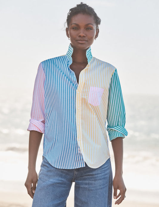 Woman wearing a colorful striped shirt with a blurred beach background