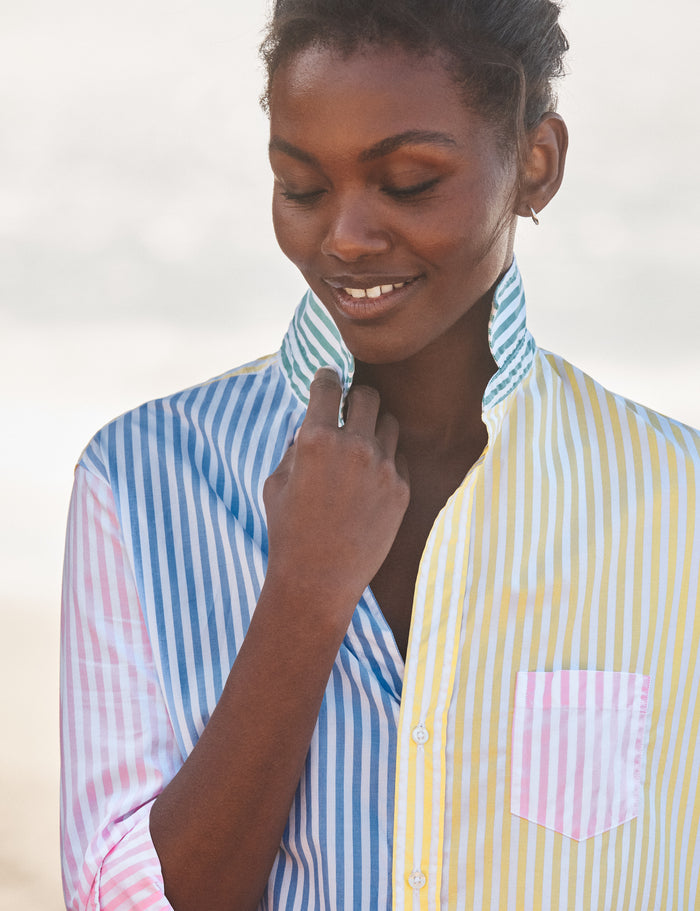 Woman wearing a colorful striped shirt with a neutral background