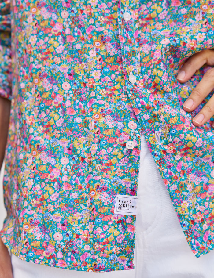 Close-up of a colorful floral shirt with a brand label on a white background
