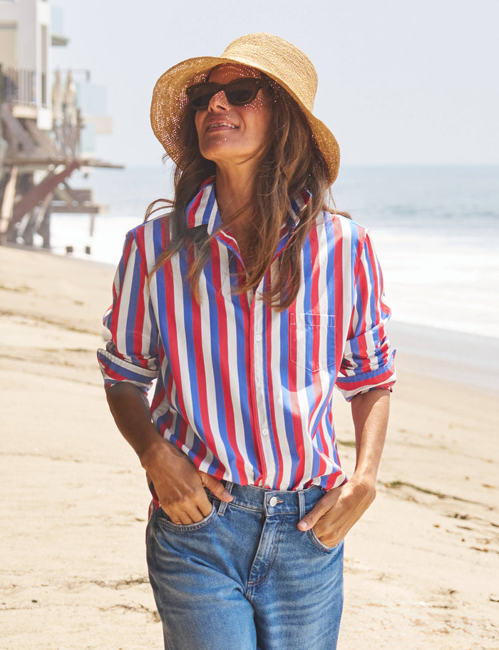 Woman wearing a red, white, and blue striped shirt on a beach.