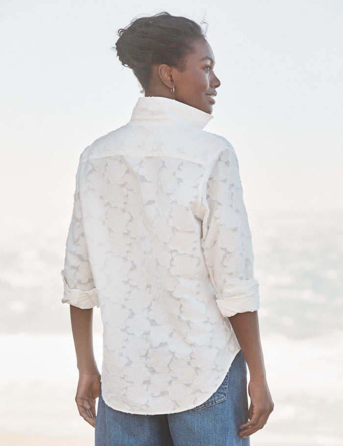 Woman wearing a white lace blouse with a blurred background