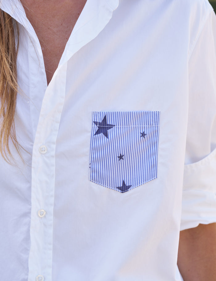White shirt with a blue pocket featuring star patterns