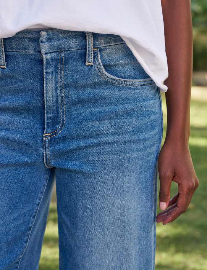 Person wearing blue jeans with a blurred background