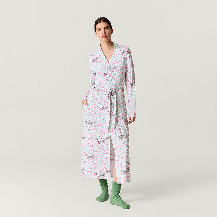 Woman wearing a long floral robe on a plain background