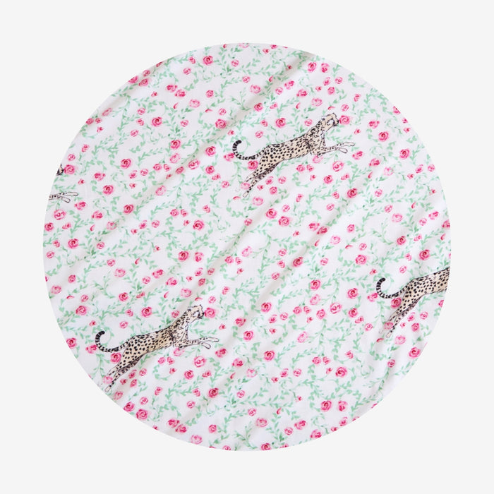 Round fabric swatch with pink floral pattern and leopards on a white background