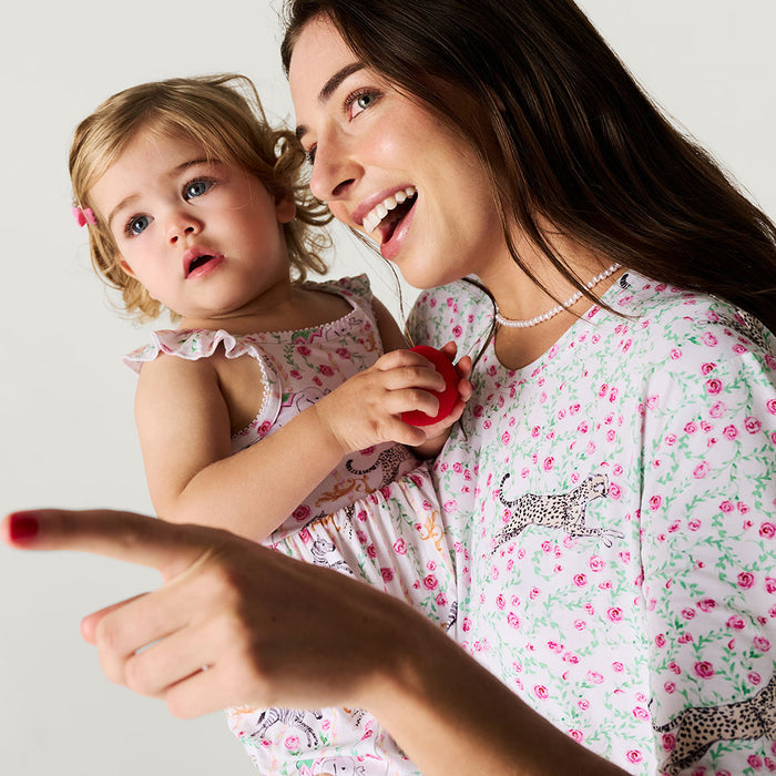Woman and child in matching floral outfits against a light background