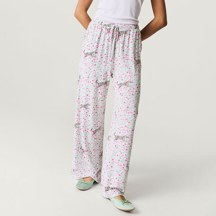 Person wearing white pajama pants with a subtle pattern on a plain background