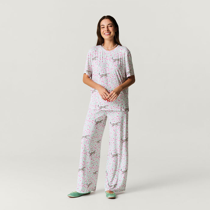 Woman wearing a floral pajama set on a plain background