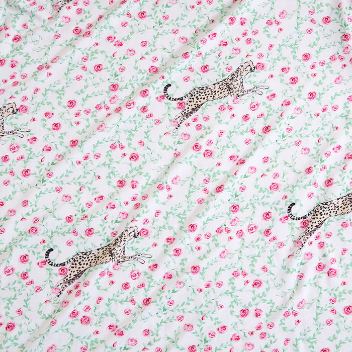 Pattern of leopards and pink flowers on a light green background