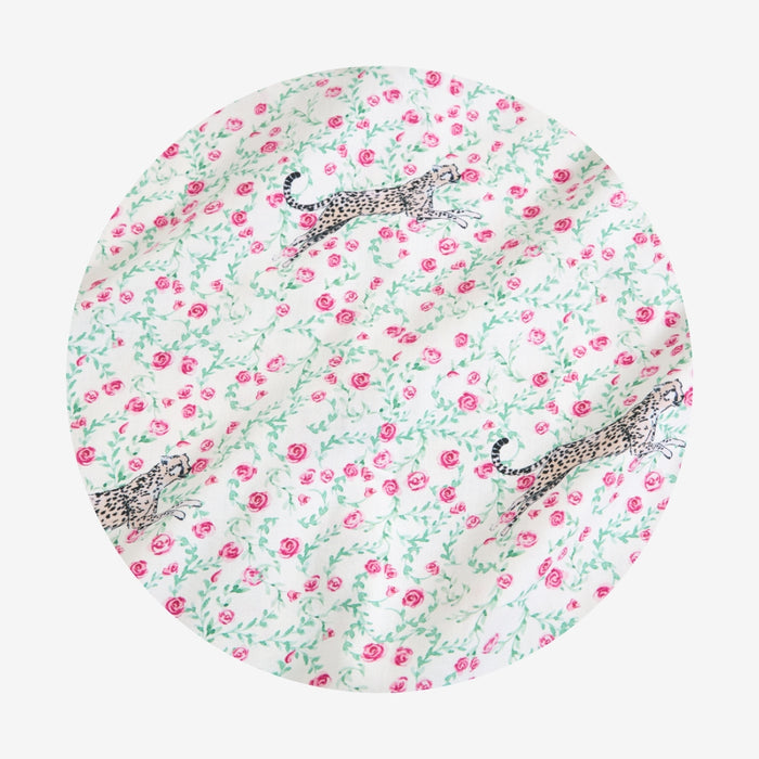 Round fabric swatch with floral pattern and animal illustrations on a white background