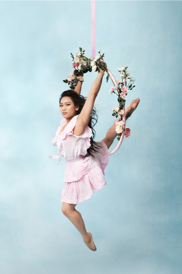 Pink hand-dyed cotton dress with lace embroidery details. Dress has a deep v neckline with ruffles on the outer edges of the shoulder and the bodice has an elastic waist and two flounced tiers.
