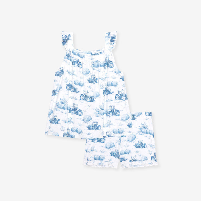 White dress with blue tractor pattern on a white background