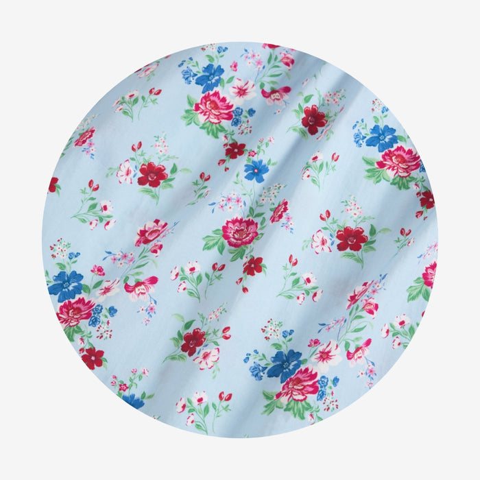 Floral fabric swatch with red, blue, and pink flowers on a light blue background