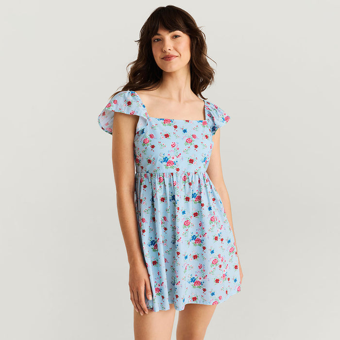 Woman wearing a floral dress on a plain background