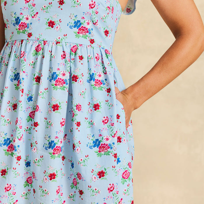 Light blue floral dress worn by a person with a beige background