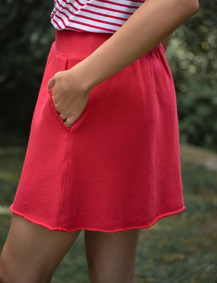 Red skirt worn by a person with a blurred green background