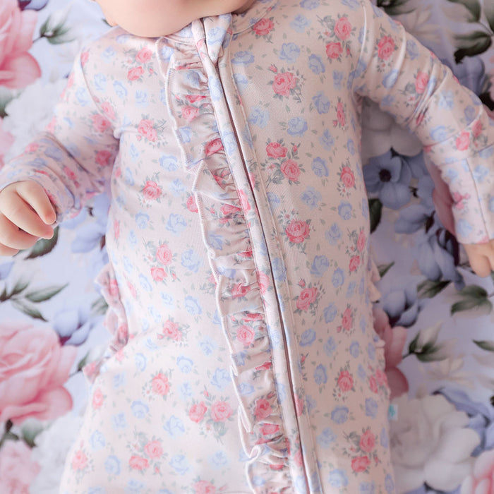 Baby in a floral sleep suit on a floral background