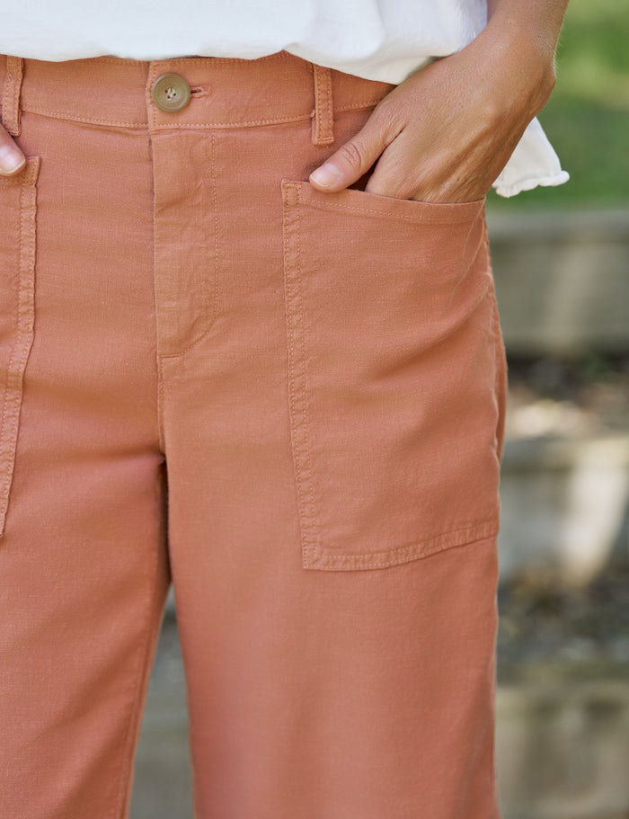 Close-up of terracotta pants with a blurred natural background