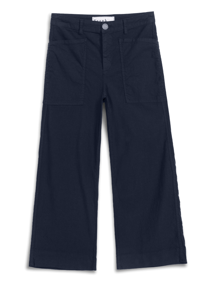 A pair of dark navy blue cropped pants with a button closure, belt loops, and two large front flap pockets, shown flat against a white background.