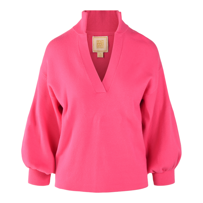 The Lolli Sweater is a bright pink, long-sleeve viscose knit blouse with a deep V-neck, blouson sleeves, ribbed cuffs and collar, plus a tan label at the back of the neck.