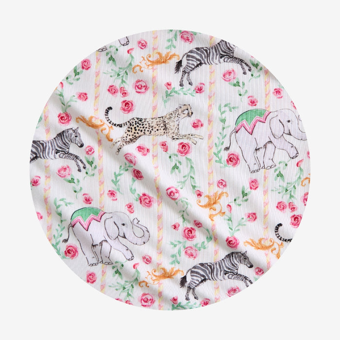 Round fabric swatch with animal and floral pattern on a white background