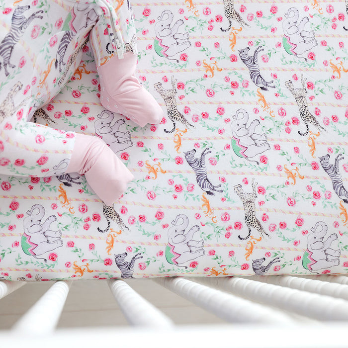 Baby crib sheet with animal and floral pattern on a white background