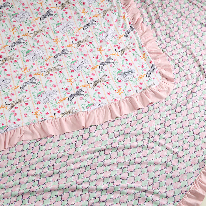 Blanket with zebra and floral pattern on top and pink and green fish scale pattern on bottom
