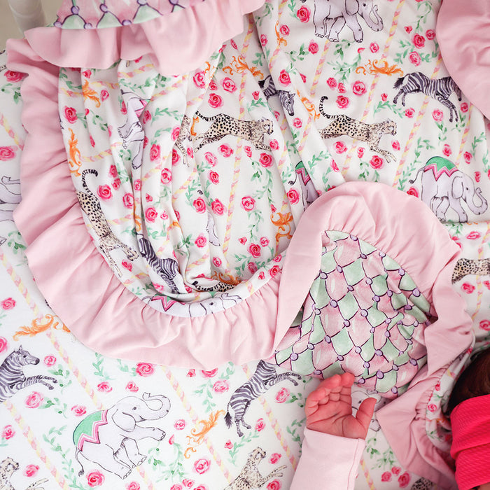 Baby blanket with colorful animal pattern and pink trim